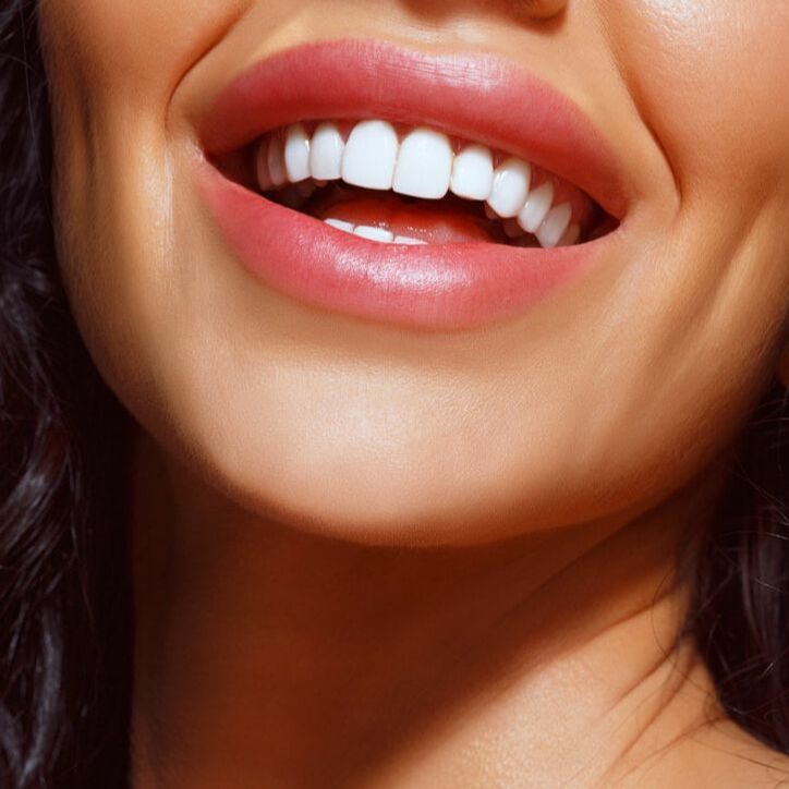 Close up of a woman smiling with pink lipstick