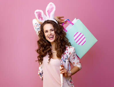Smiling woman on pink background with Easter shopping bag